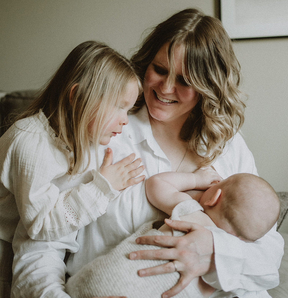 Maman qui allaite à côté de sa petite fille