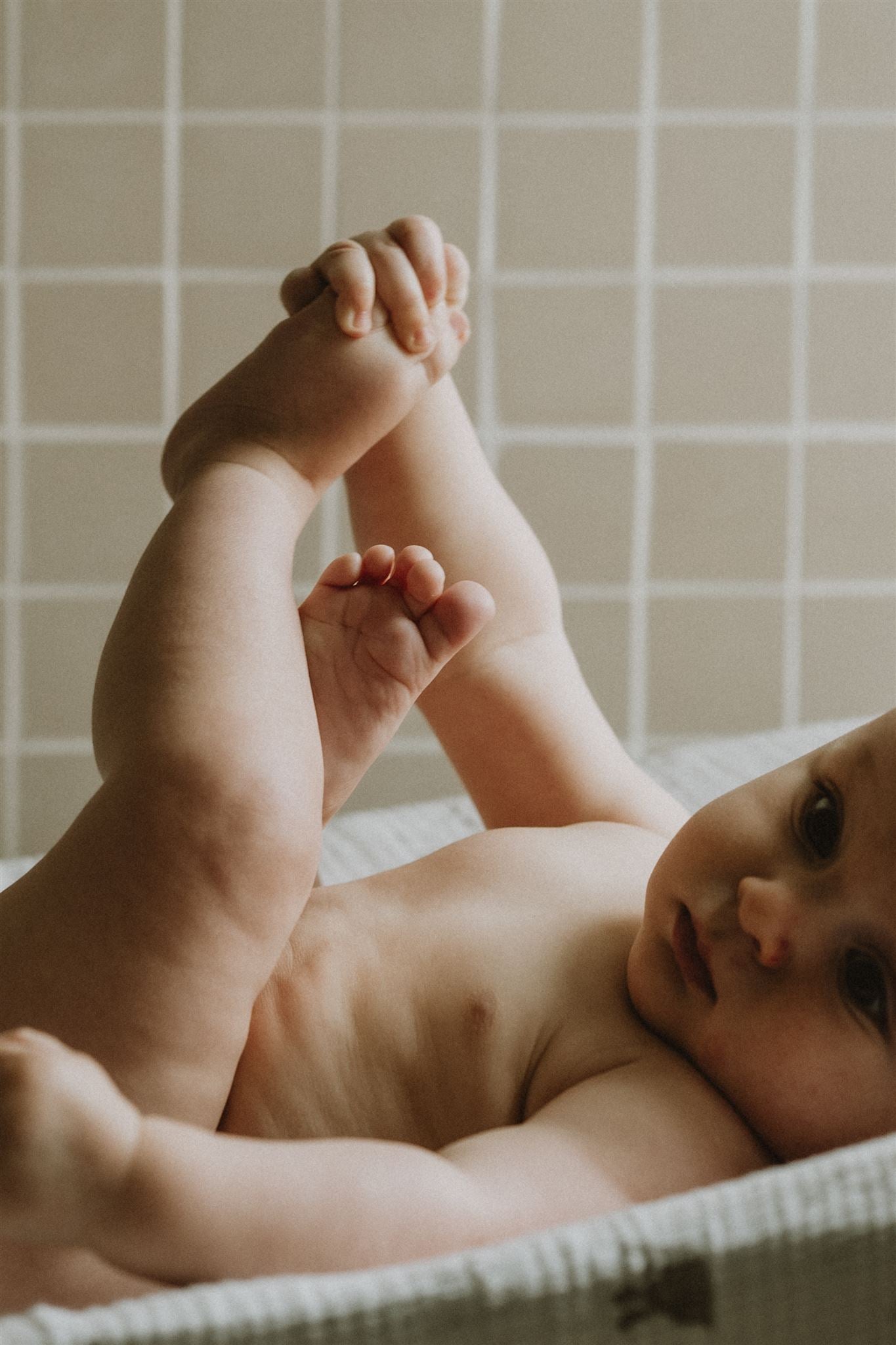 Bébé couché dans un lange après soin au liniment Fleurs de Peau