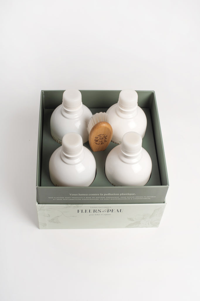 Vue du dessus du coffret Fleurs de Peau avec quatre soins bébé et une brosse
