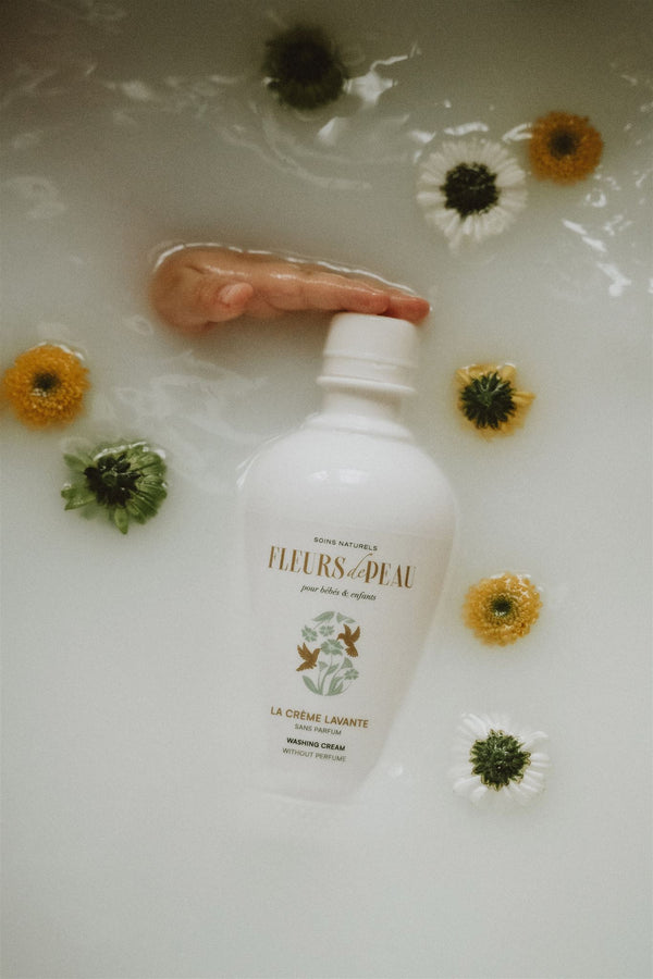 Crème lavante bébé Fleurs de Peau flottant dans l’eau avec fleurs