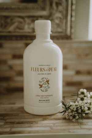 Eau nettoyante bébé Fleurs de Peau posée avec fleurs blanches