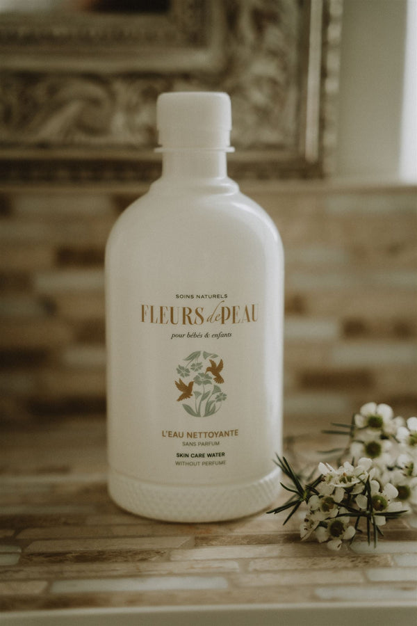 Eau nettoyante bébé Fleurs de Peau posée avec fleurs blanches